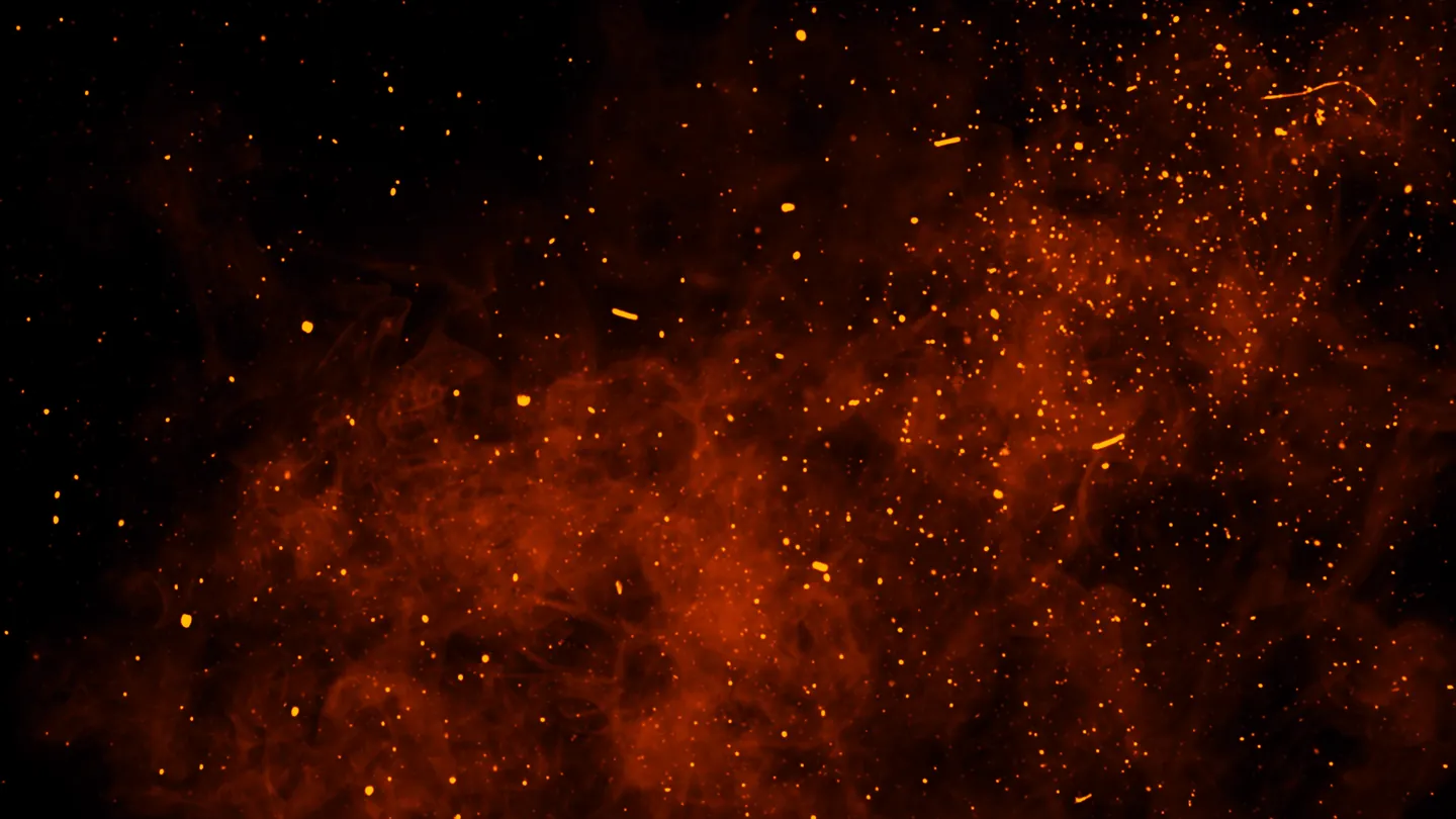 Glowing airborne embers against a dark background
